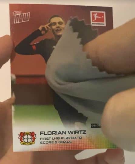 Cleaning A Trading Card With A Microfiber Cloth